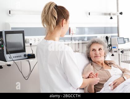 elderly woman in a hospital ward receives nursing care. Recovery after surgery, patient in the ward Stock Photo