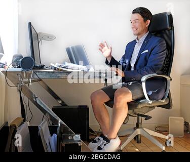 Working from home: man wearing a suit for the video call while also wearing sweatpants Stock Photo