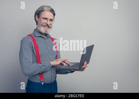Profile side view portrait of his he nice attractive classy confident cheerful cheery man leader partner holding in hands laptop working remotely Stock Photo
