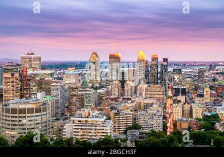 Beautiful pink sunset over the illuminated Montreal skyline shot from Mount Royal hill on a summer day, Quebec, Canada Stock Photo