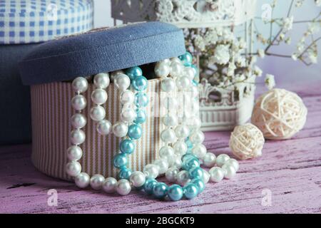 Decorative boxes with beads and flowers on table close up Stock Photo