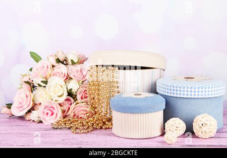 Decorative boxes with flowers on table on bright background Stock Photo