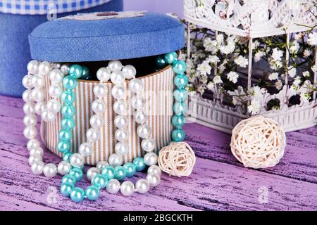 Decorative boxes with beads and flowers on table close up Stock Photo