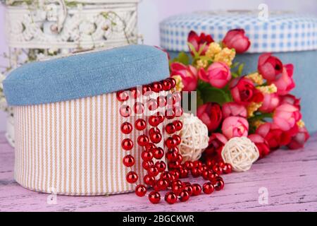 Decorative boxes with beads and flowers on table close up Stock Photo