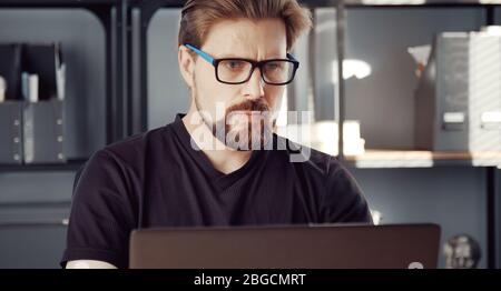 Serious man using laptop Stock Photo
