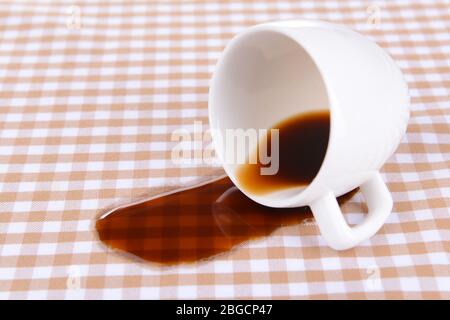 Overturned cup of coffee on table close-up Stock Photo