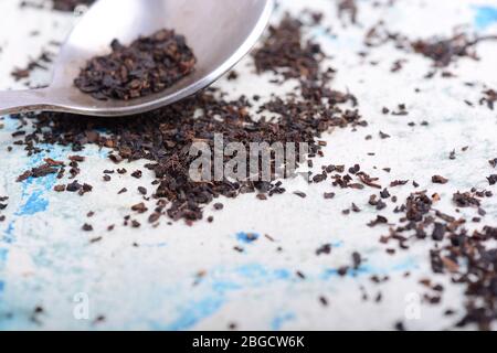 Black tea in a spoon on a white background. Close up shot Stock Photo
