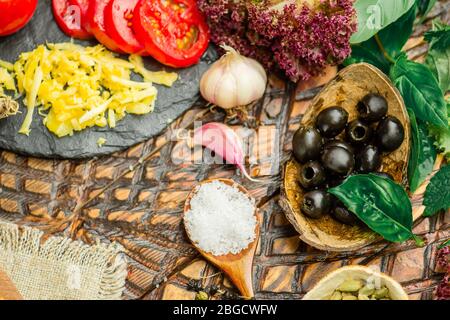 Fresh baked pizza on cutting board. Tasty pizza and fresh vegetables. Margarita pizza with ham mushrooms and ketchup. Colorful  pizza and vegetables a Stock Photo