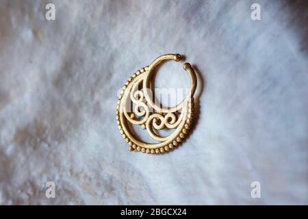 Brass metal nose decorative septum oriental boho jewelry on natural white shell background Stock Photo