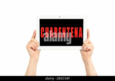 hands holding a tablet on a white background with quarantine text in spanish Stock Photo