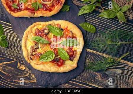Mixed pizza with chicken, pepper, olives, onion, basil on pizza board. Close up view of baked homemade piza. Rustic pizza home made food. Stock Photo