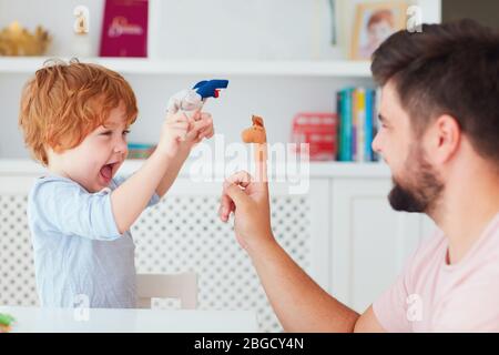 happy father playing with kids at home, funny puppet games Stock Photo