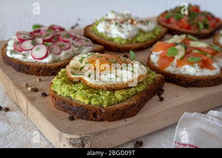 Set of aperitif sandwiches with avocado, egg, salmon Stock Photo