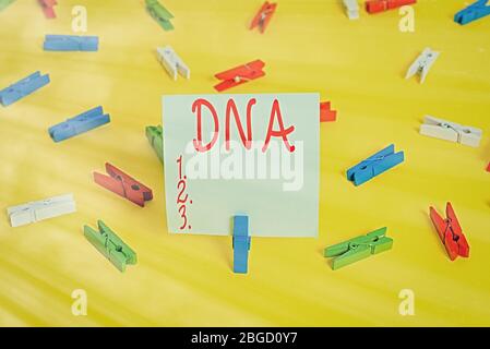 Word writing text Dna. Business photo showcasing a selfreplicating material wpresent in nearly all living organisms Colored clothespin papers empty re Stock Photo