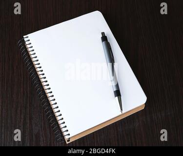 Notebook with pen on color wooden background Stock Photo
