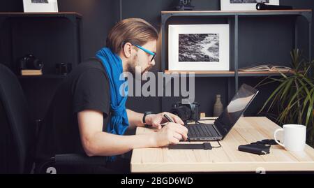 Photographer retouching pictures, side view Stock Photo