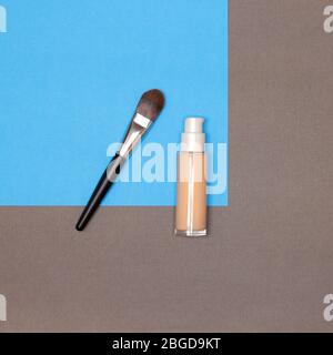 Liquid fluid make-up foundation bottle with flat makeup brush. Top view, close-up Stock Photo