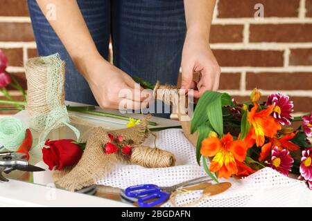 Female hands composing beautiful bouquet, close-up. Florist at work. Conceptual photo Stock Photo