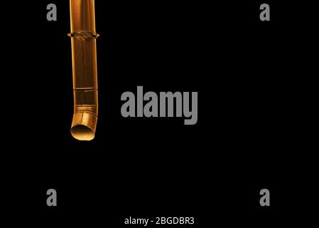 Drainpipe on a black background with copy space. Contemporary art, minimalism Stock Photo