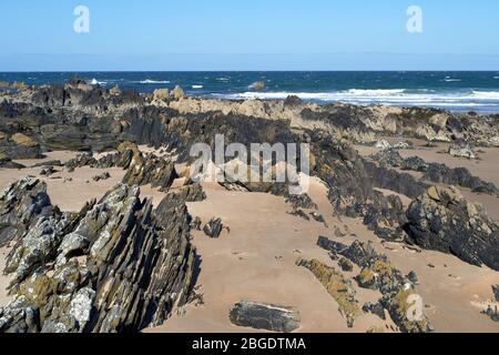 SUNNYSIDE BAY CULLEN MORAY FIRTH SCOTLAND ROCK FORMATIONS ACROSS THE SANDY BEACH AT LOW TIDE Stock Photo