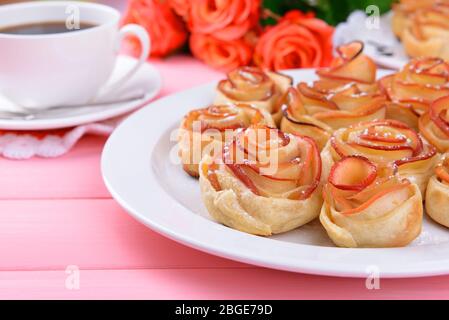 Tasty  puff pastry with apple shaped roses on plate on table close-up Stock Photo