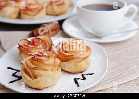 Tasty  puff pastry with apple shaped roses on plate on table close-up Stock Photo