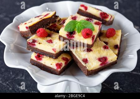 delicious vegetarian Raspberry Cheesecake Bars on a white cake stand,  horizontal view from above, close-up Stock Photo