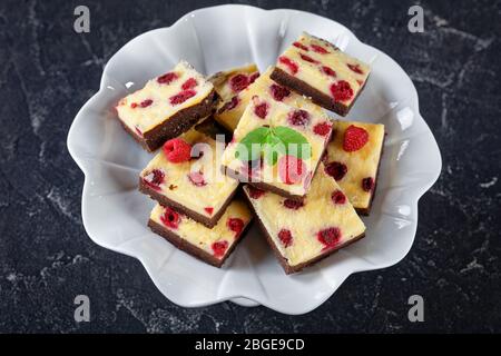 delicious vegetarian Raspberry Cheesecake Bars on a white cake stand, flat lay, horizontal view from above Stock Photo