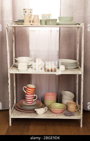 Different tableware on shelf in the interior Stock Photo