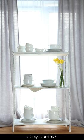 Different tableware on shelf in the interior Stock Photo