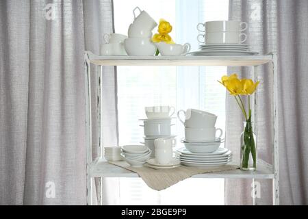 Different tableware on shelf in the interior Stock Photo