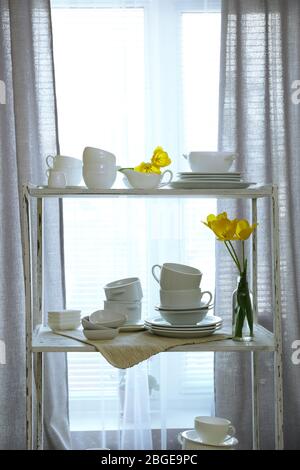 Different tableware on shelf in the interior Stock Photo