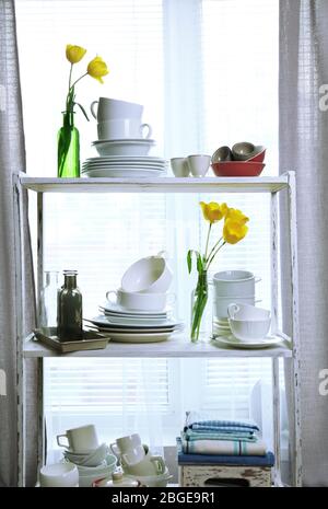 Different tableware on shelf in the interior Stock Photo
