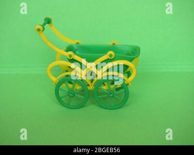 empty green plastic toy baby pushchair (aka stroller) Stock Photo