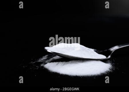 Spoon of baking soda on black background Stock Photo