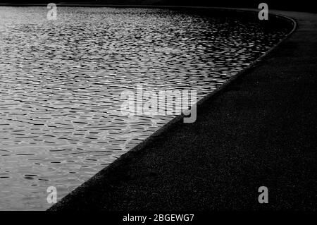 Beautiful designed garden fish pond with water-lily in a well cared backyard gardening background. Stock Photo