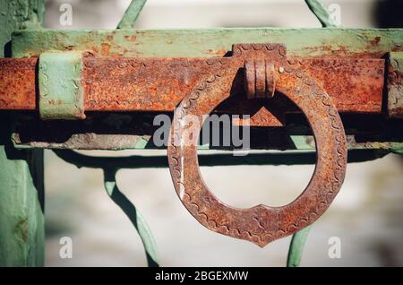 exterior view of a really old, closed and rusty green iron gate Stock Photo