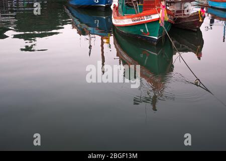 CHON BURI, THAILAND - FEBRUARY 16, 2019: Water reflection of the local fisherman boat mooring at Local fisherman port, fisherman village near Pattaya Stock Photo