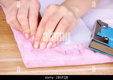 Fastening fabric and board using construction stapler Stock Photo