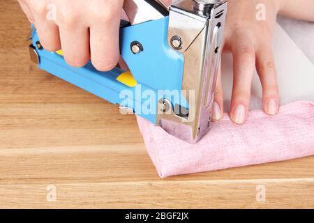 Fastening fabric and board using construction stapler Stock Photo