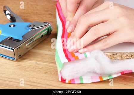 Fastening fabric and board using construction stapler Stock Photo