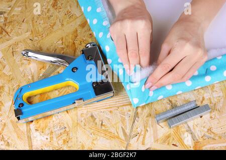 Fastening fabric and board using construction stapler Stock Photo