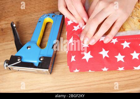 Fastening fabric and board using construction stapler Stock Photo