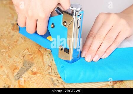Fastening fabric and board using construction stapler Stock Photo