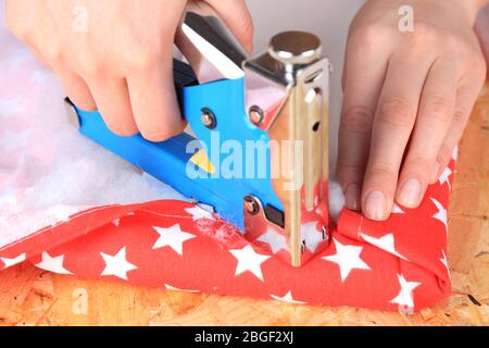 Fastening fabric and board using construction stapler Stock Photo