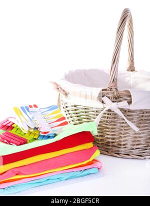 Bright clothes and empty wicker basket, isolated on white Stock Photo