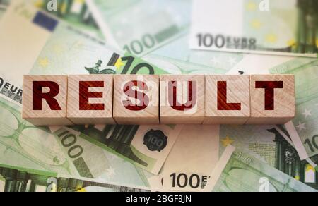 Result word on Wooden Blocks on many 100 Euro banknotes. Productive profitable business marketing concept Stock Photo