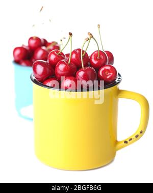 Sweet cherries in mugs isolated on white Stock Photo