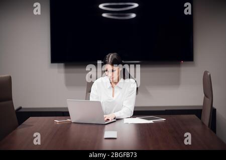 Beautiful young businesswoman using laptop in conference room Stock Photo