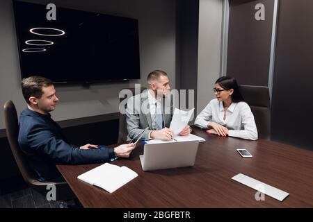 Coworkers meeting at conference room to discuss project in office Stock Photo